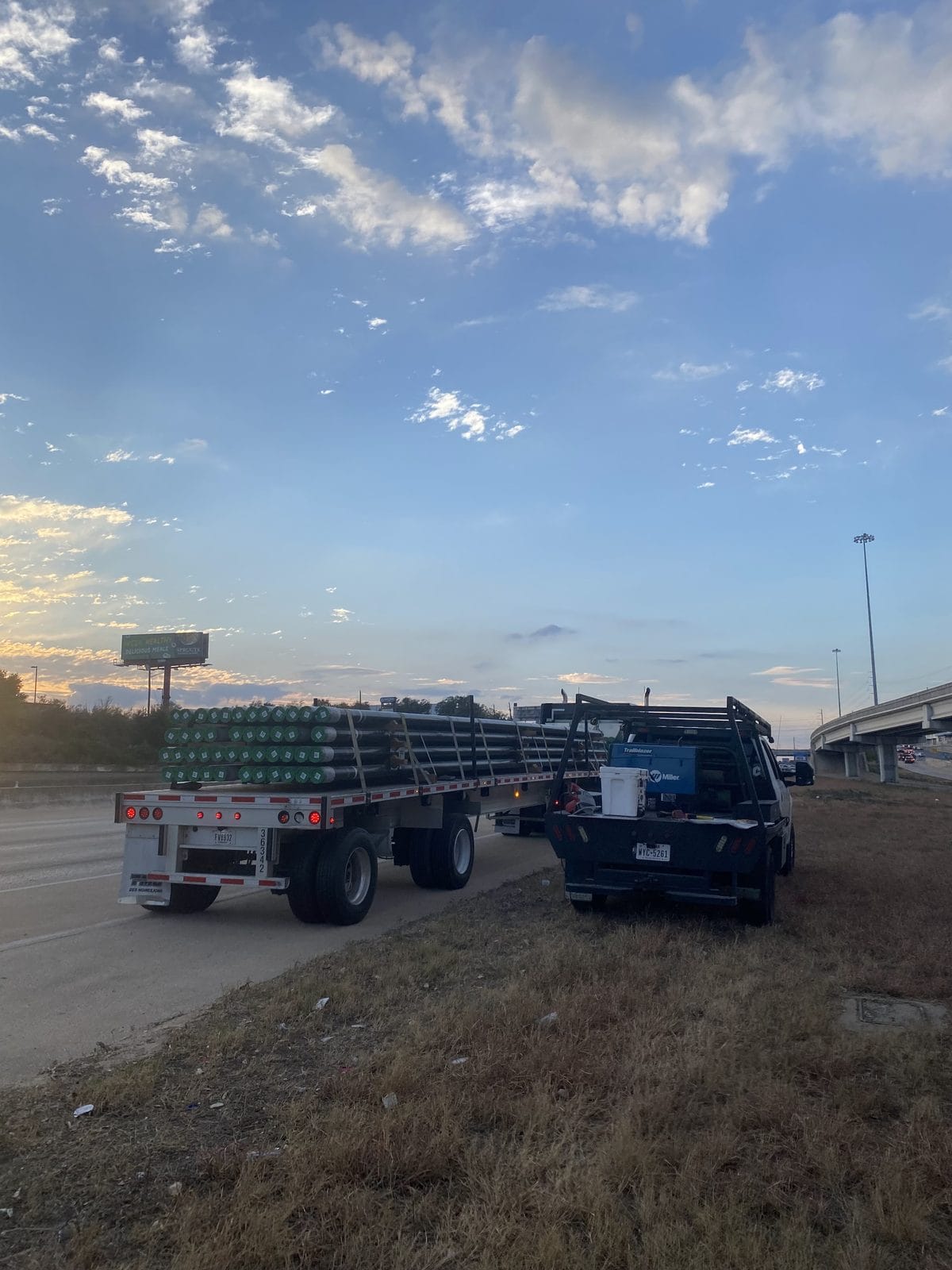 Loaded flatbed trailer and mobile welding rig on site